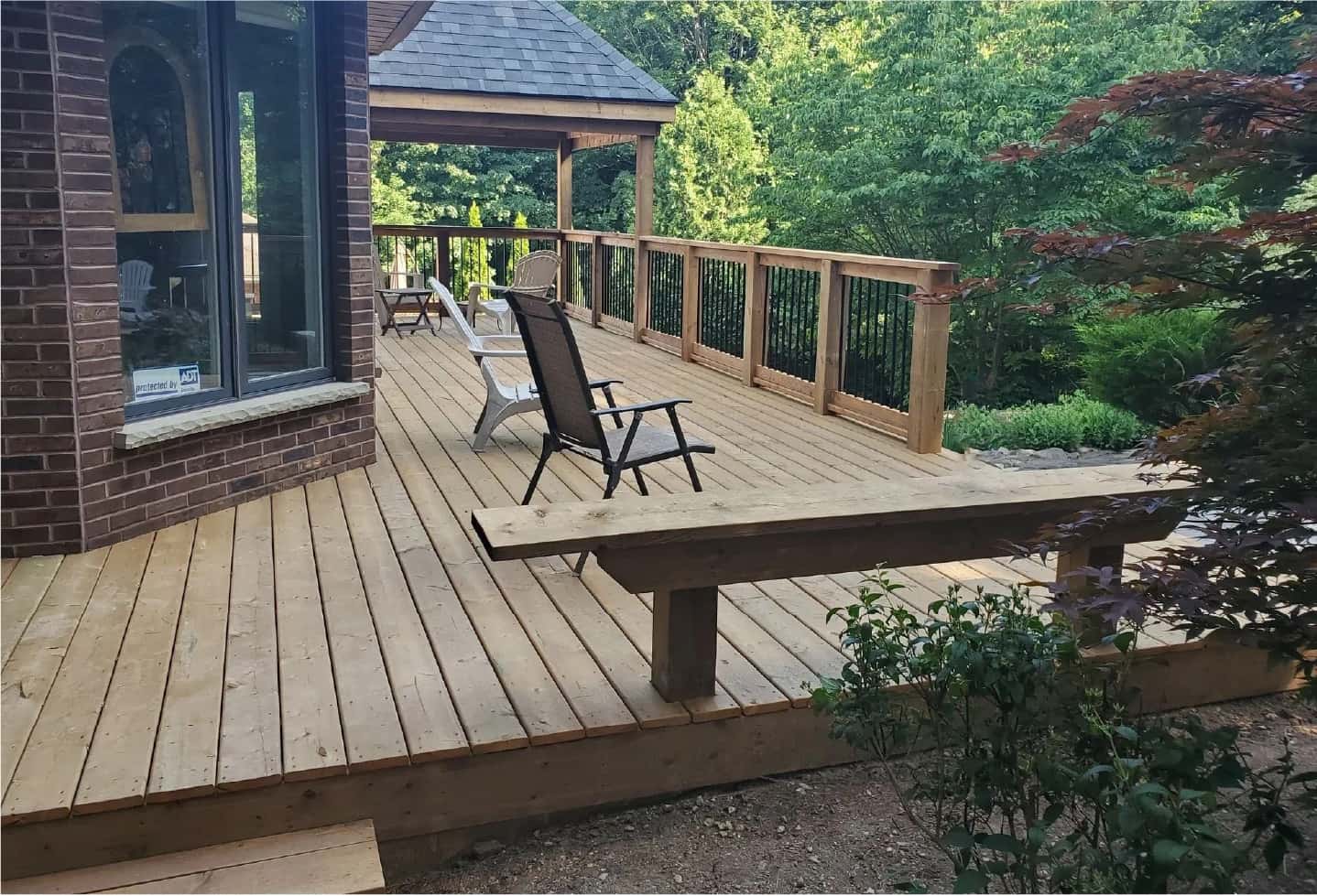 newly renovated wood deck with railing, bench and gazebo
