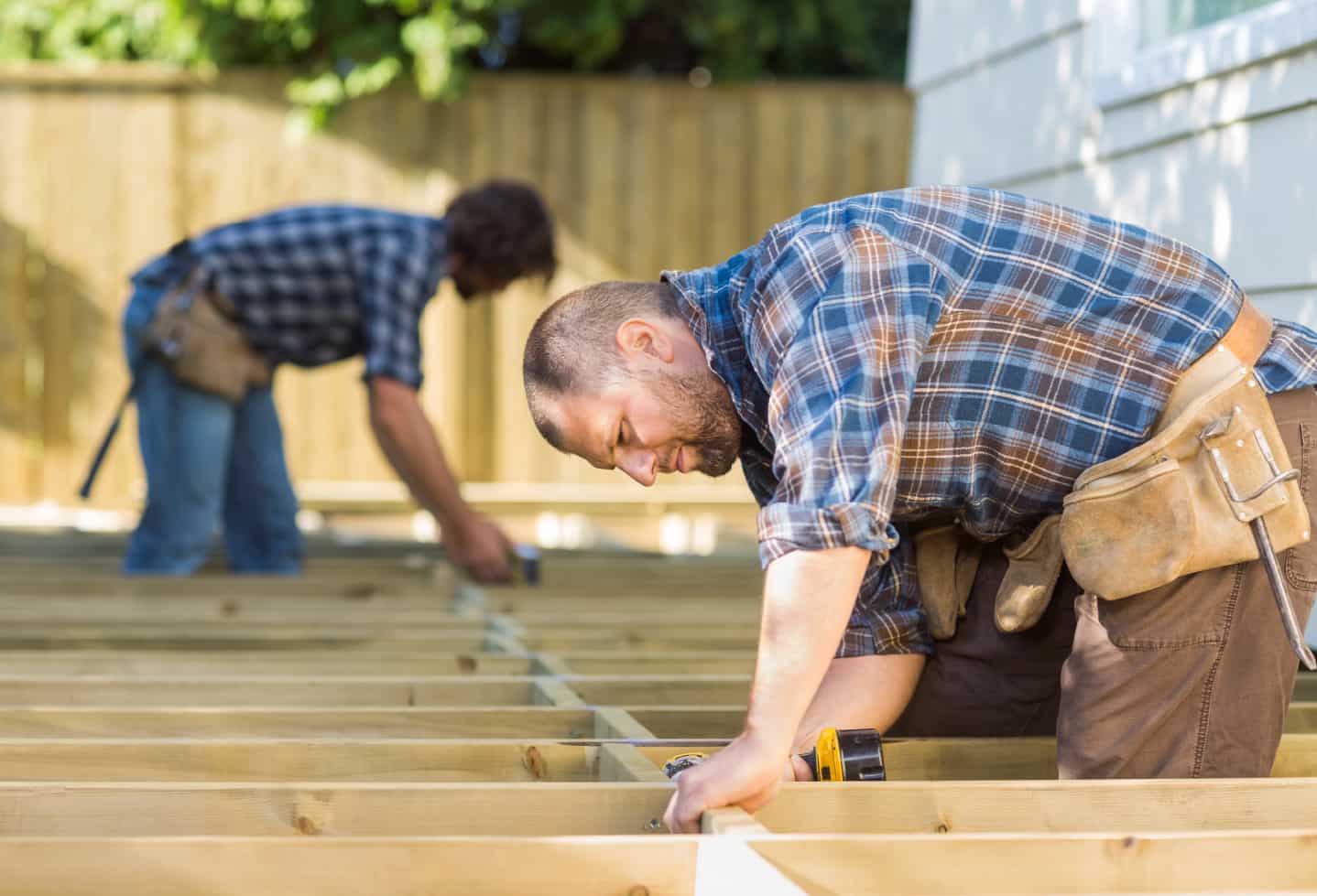 two carpenters working on a wood patio