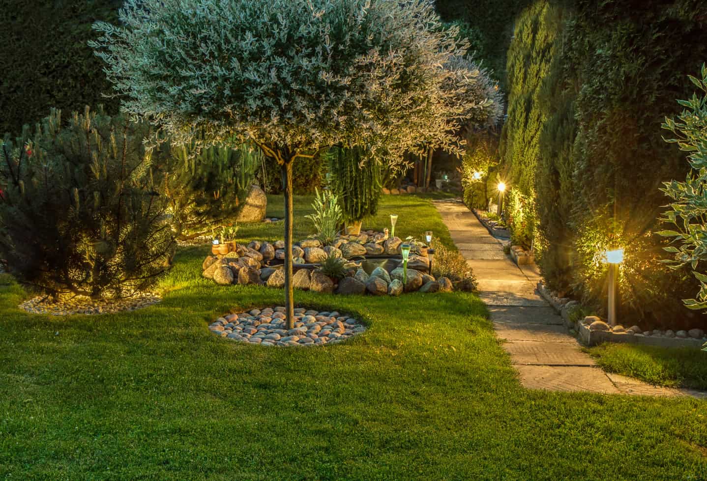 Backyard garden with lights on a night. rock features throughout. before after night day shot