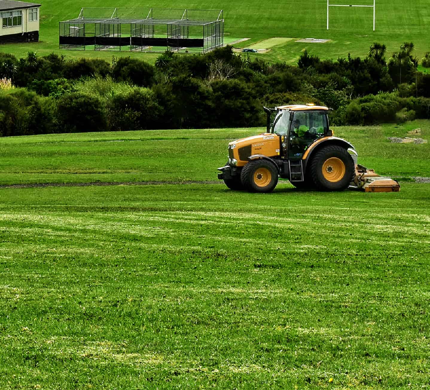 tractor cutting lawn of large farm or rural space