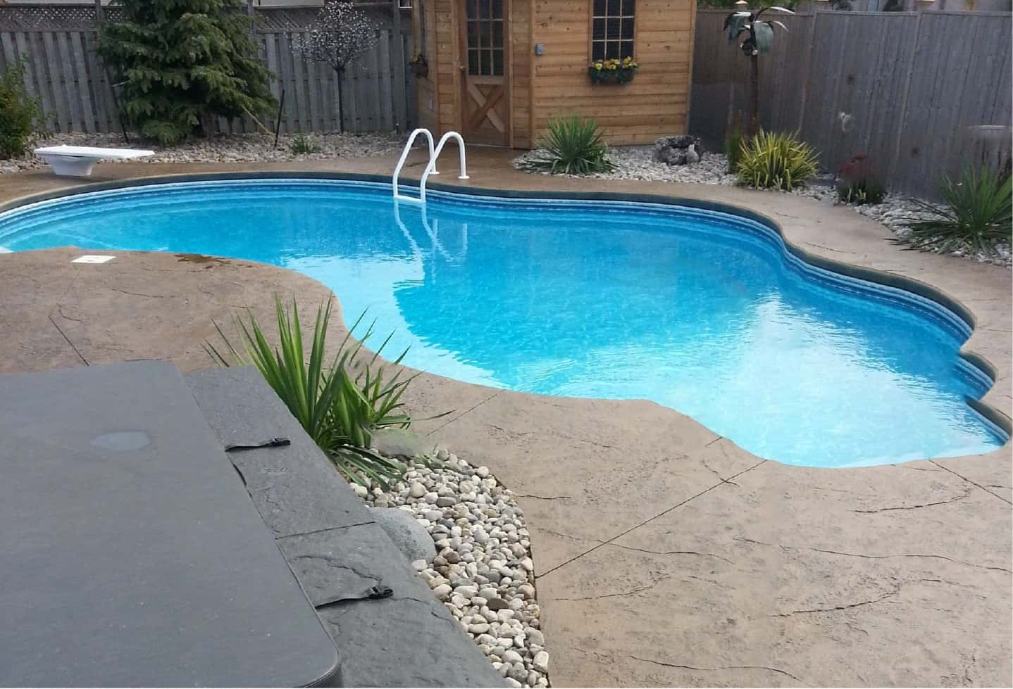swimming pool with cement patio backyard