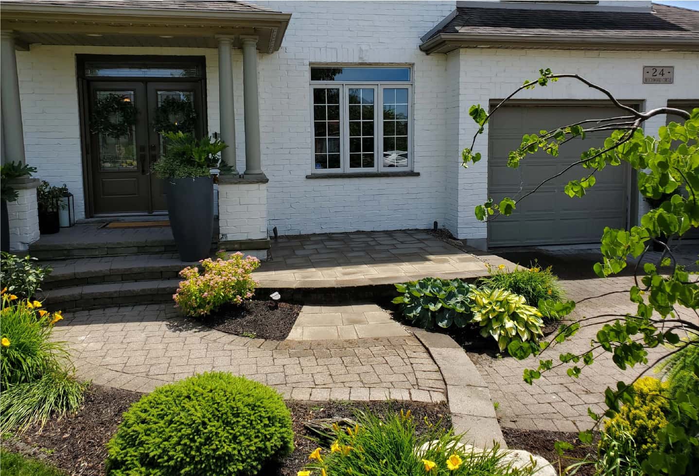 landscaping work on front yard of large house. with new hardscape installation