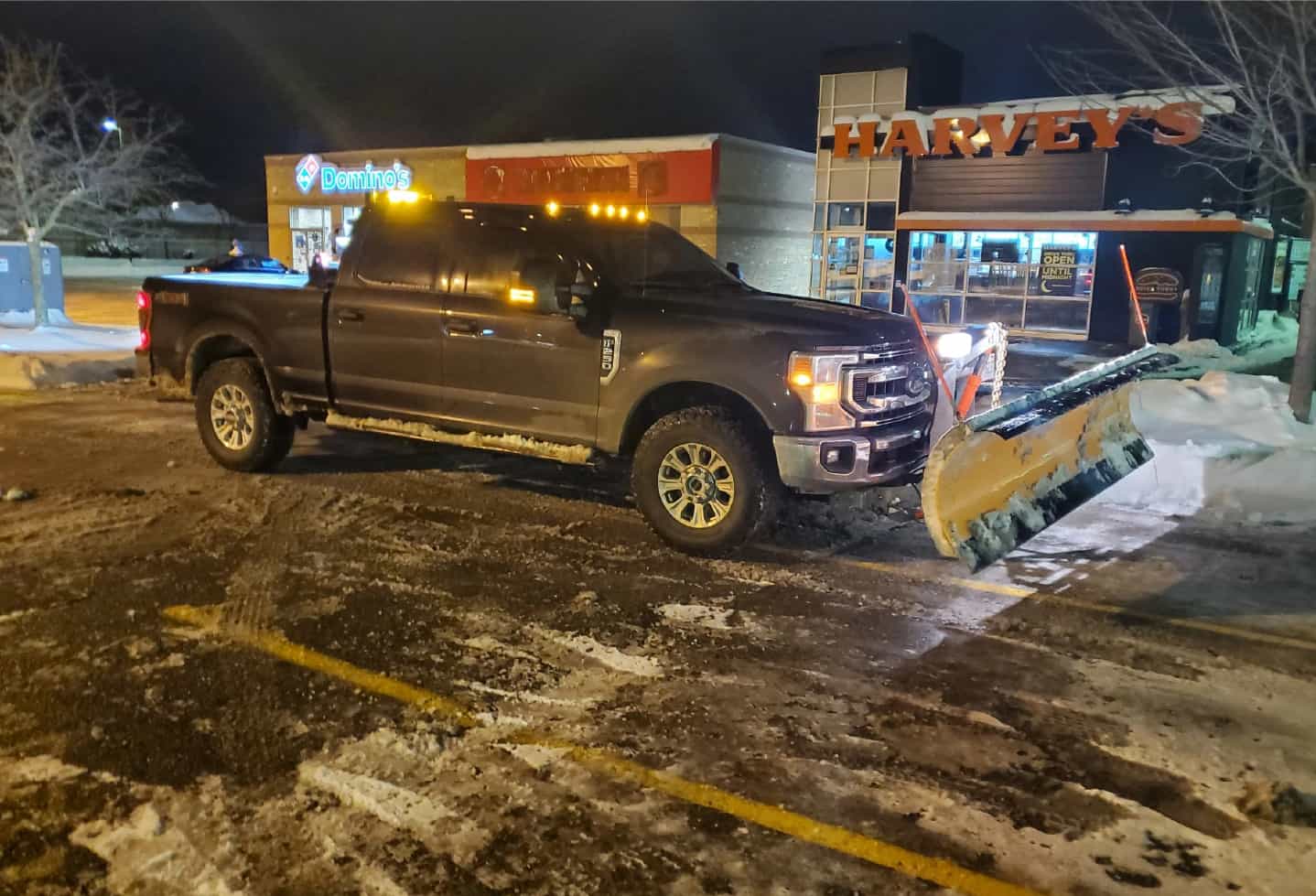 truck with snow plow at night
